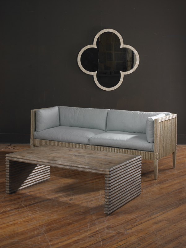The Belmont Coffee Table in Rustic Grey Pine sits in front of a modern sofa on wooden floors.