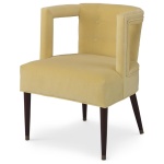 The Eliza Chair shown in Turmeric Velvet sits in a studio.