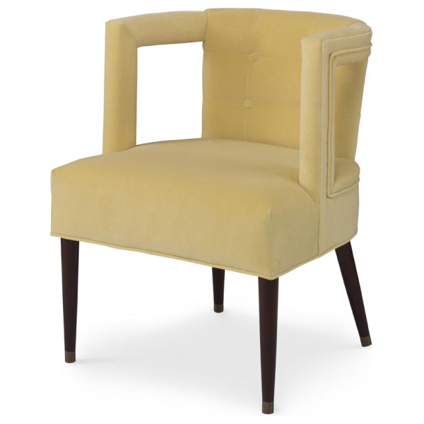 The Eliza Chair shown in Turmeric Velvet sits in a studio.