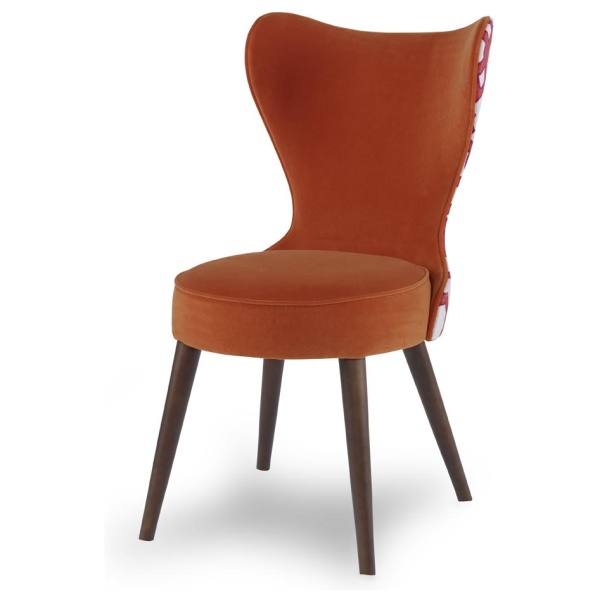 The Maribella Chair in Marmalade Velvet with Custom COM back sits in a studio.