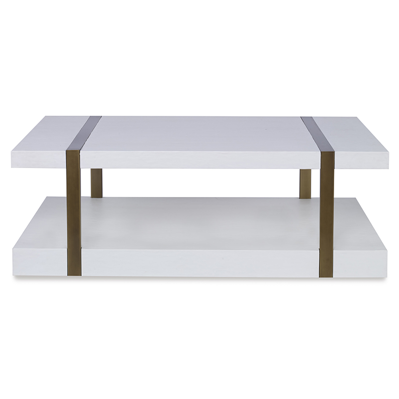 The Mercer Coffee Table in Smooth White Gesso with Finished Aged Brass sits in a studio.