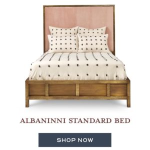 A wooden bed with a soft, fabric headboard.