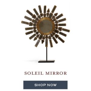 A metal and mirrored piece of home décor designed to look like the sun.